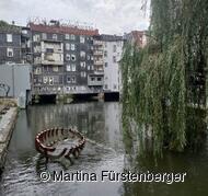 Das Bild zeigt die Esslinger Kanäle. Im Hintergrund sind Häuser zu sehen mit Wasser im Vordergrund. 