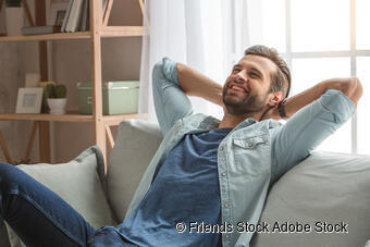 Ein glücklicher Mann entspannt sich auf einer Couch Ein glücklicher Mann entspannt sich auf einer Couch